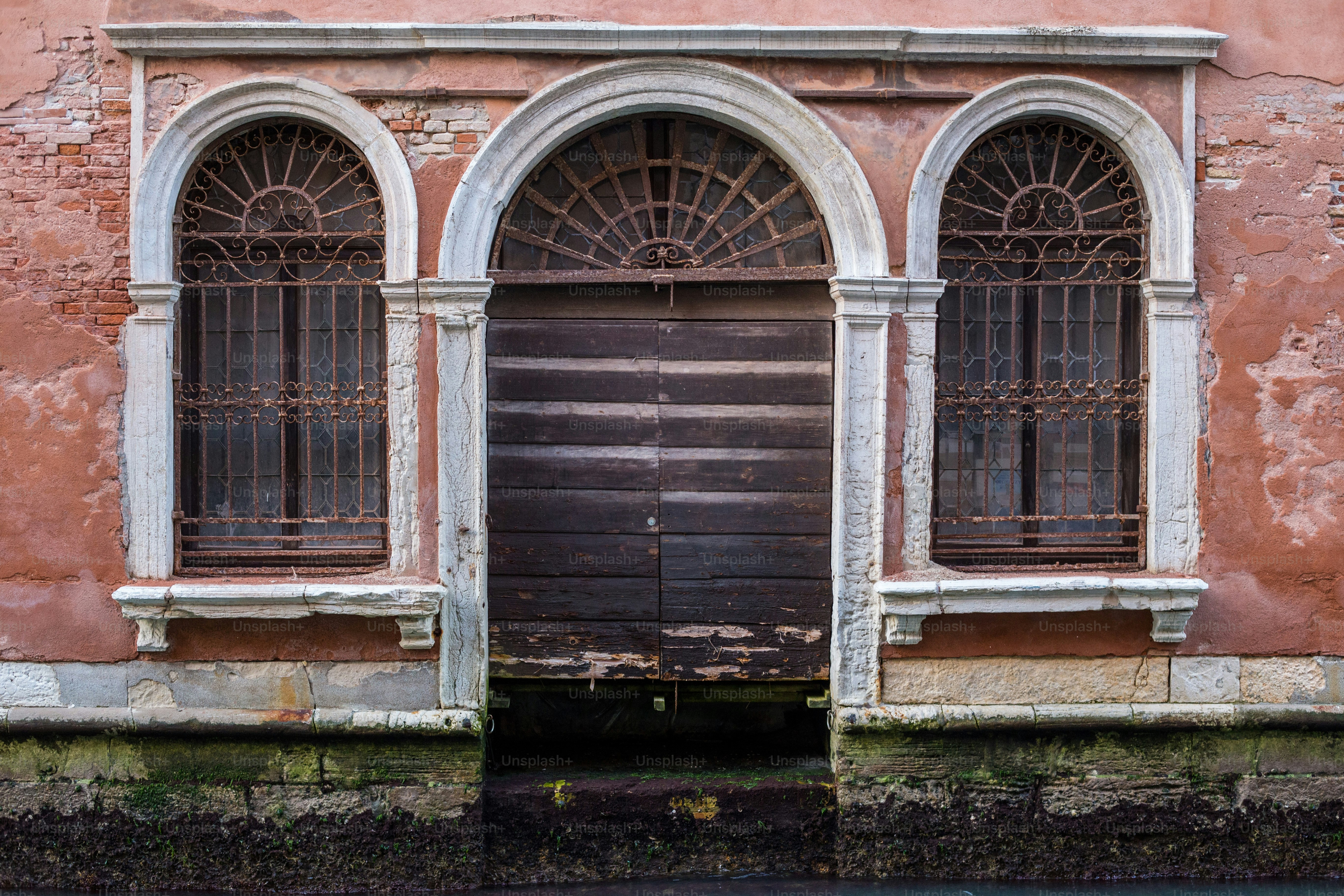 an old building with a wooden door and arched windows