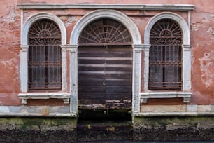 木製のドアとアーチ型の窓がある古い建物