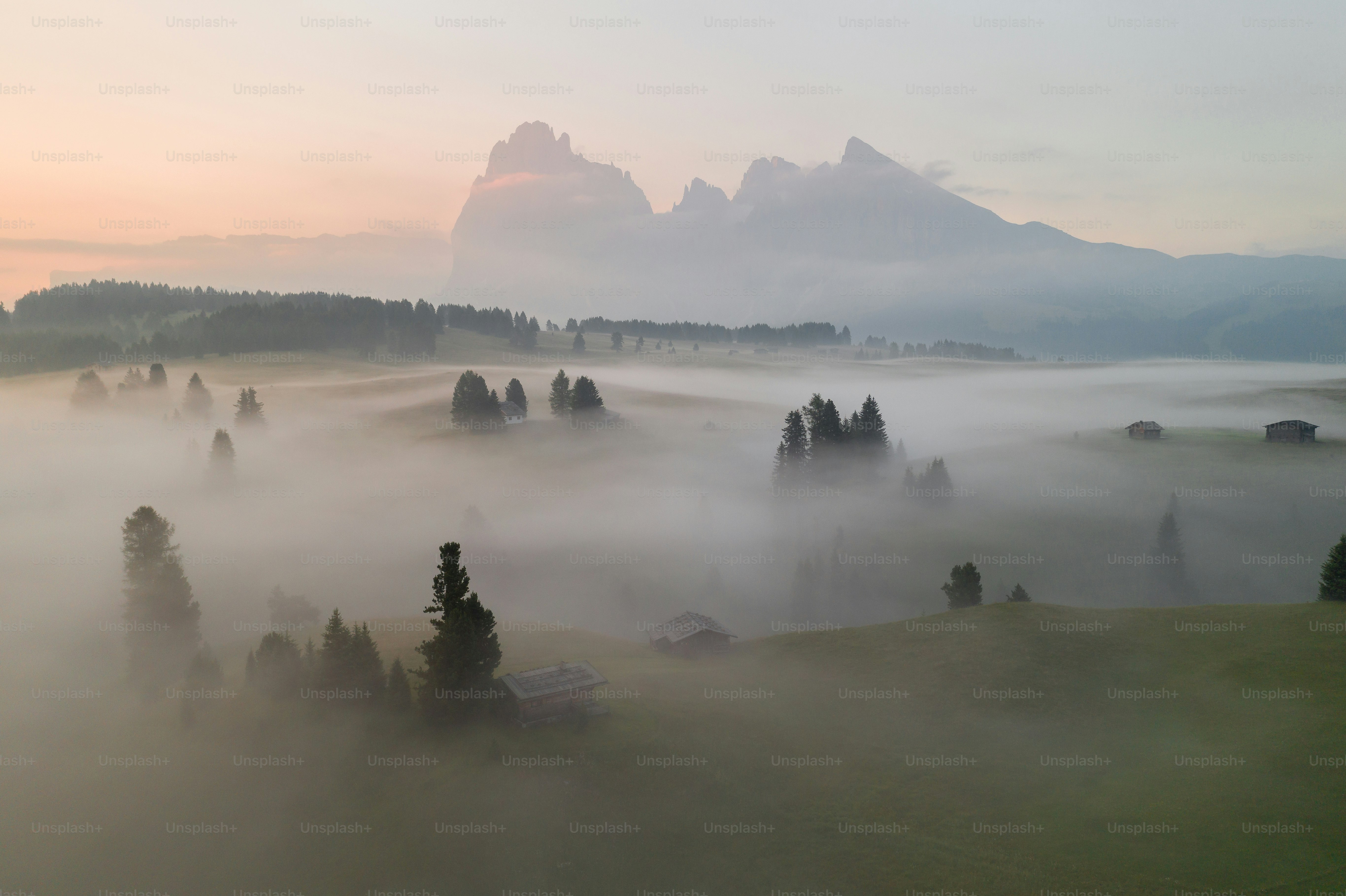 a foggy landscape with mountains in the distance