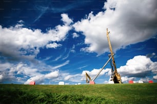 a large crane sitting on top of a lush green field