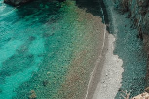 an aerial view of a beach with clear blue water