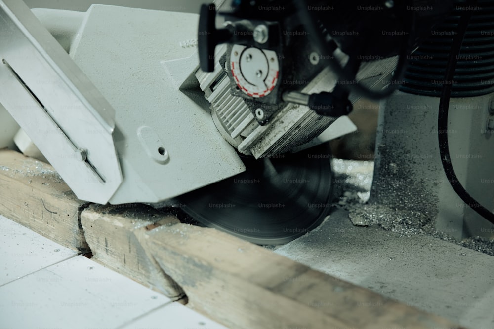 a close up of a machine cutting a piece of wood