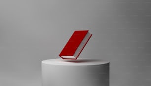 a red book sitting on top of a white pedestal