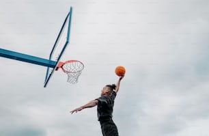 Ein Mann spielt Basketball an einem bewölkten Tag
