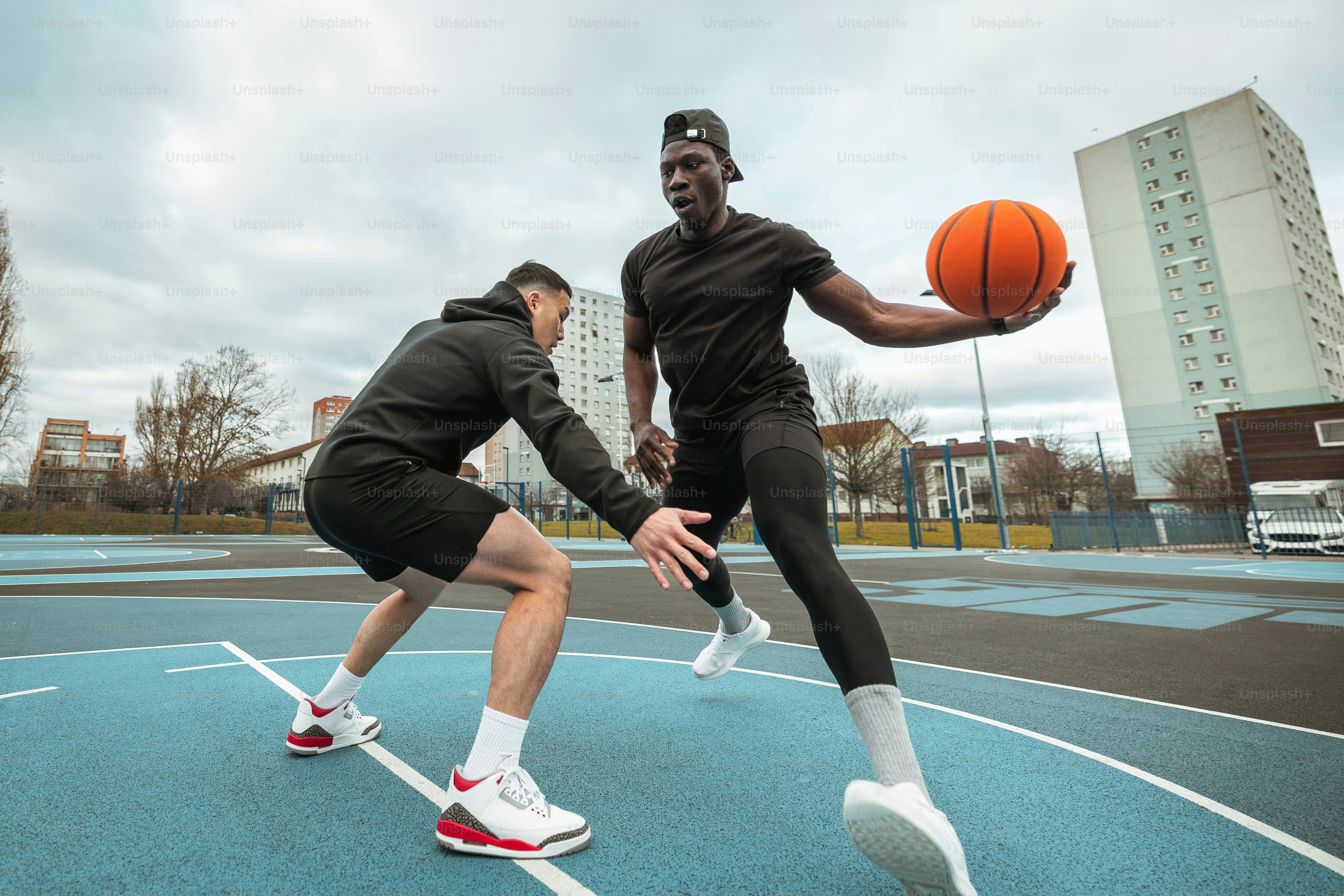 a couple of men playing a game of basketball