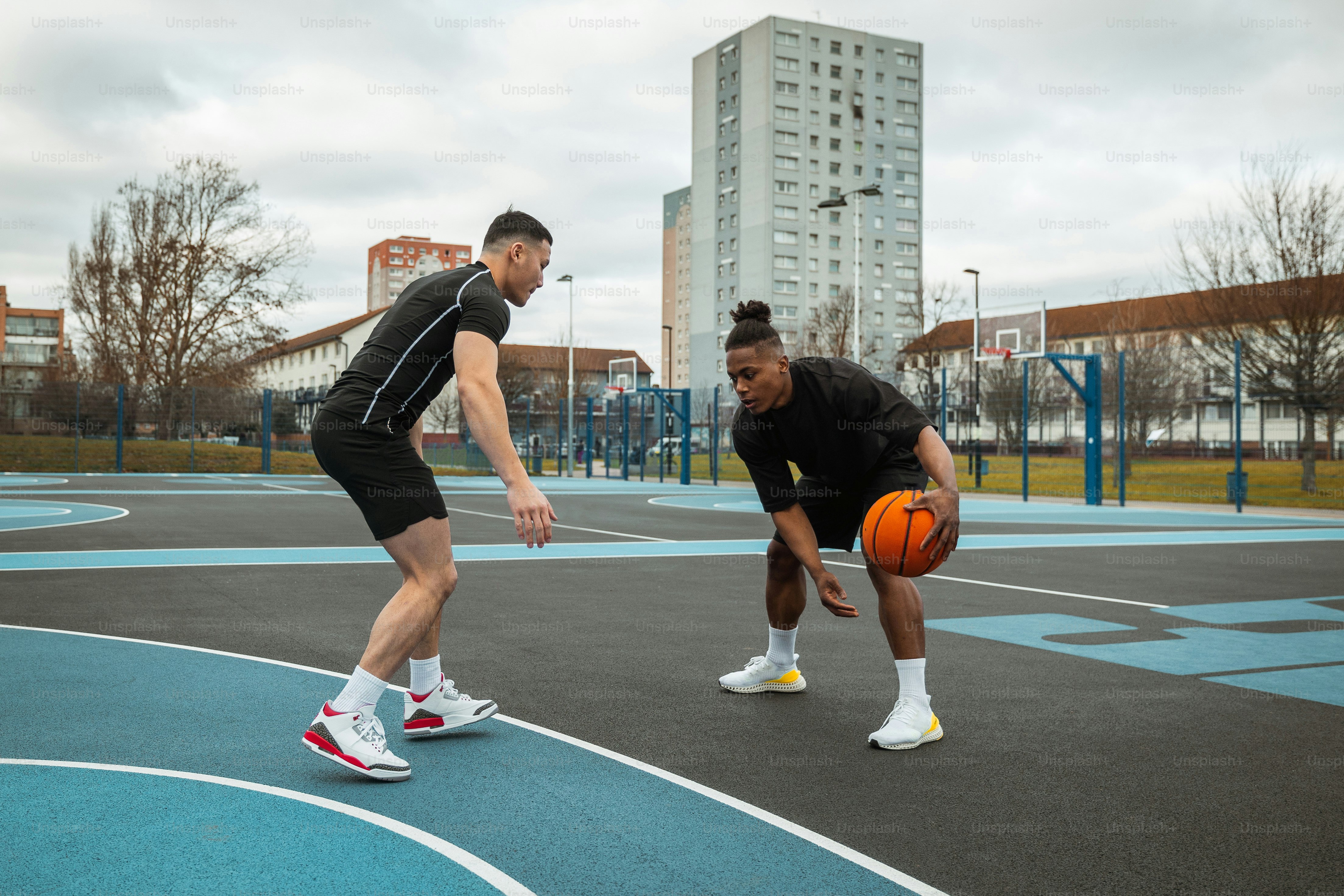 a couple of men standing on top of a basketball court