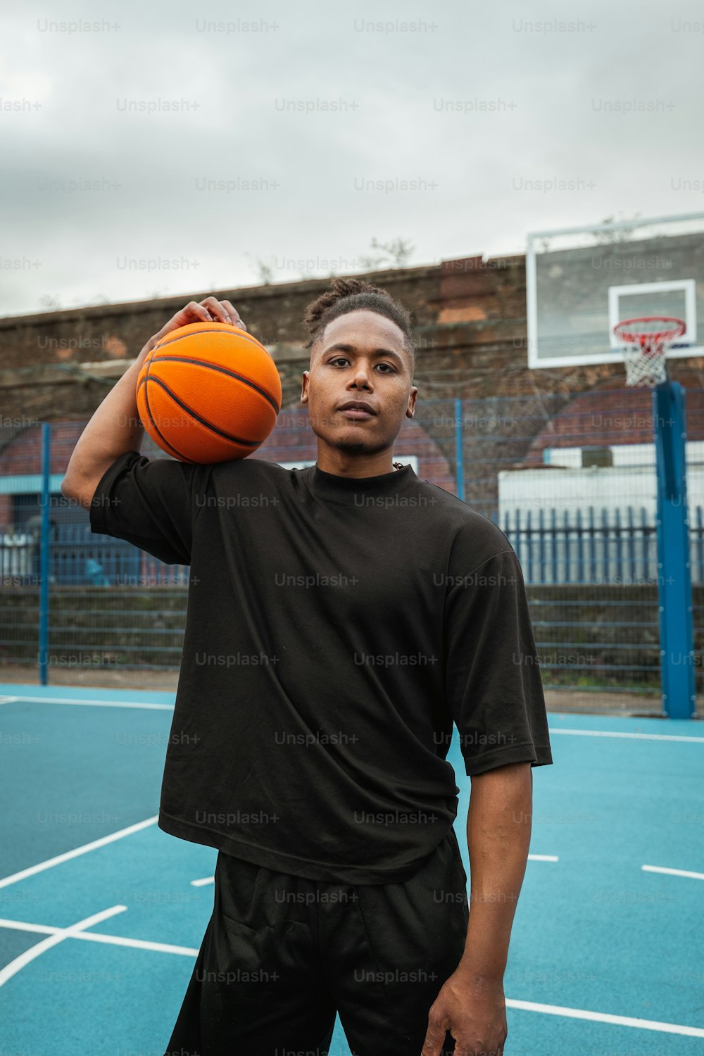 Un hombre sosteniendo una pelota de baloncesto en una cancha de baloncesto