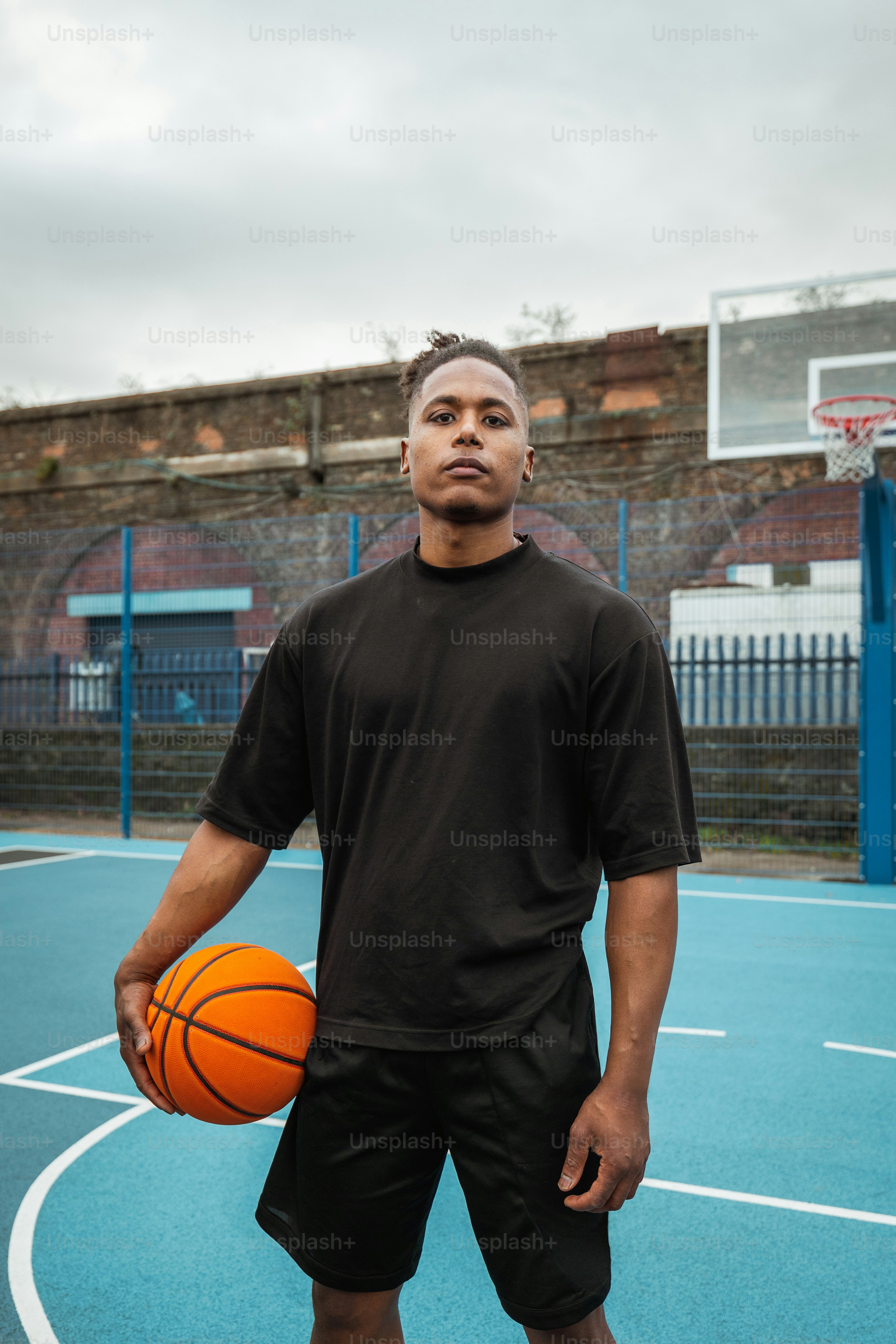 a man standing on a basketball court holding a basketball