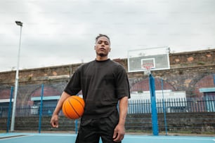 Ein Mann, der auf einem Basketballplatz steht und einen Basketball hält