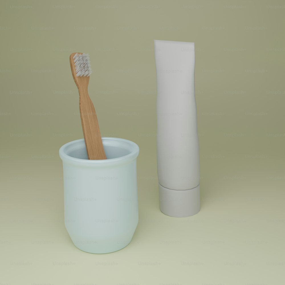a toothbrush in a cup next to a tube of toothpaste