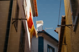 建物の側面にぶら下がっているオレンジと黄��色の旗