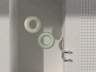 ein Badezimmer mit einer weiß gefliesten Wand und einer grün-weißen Toilette