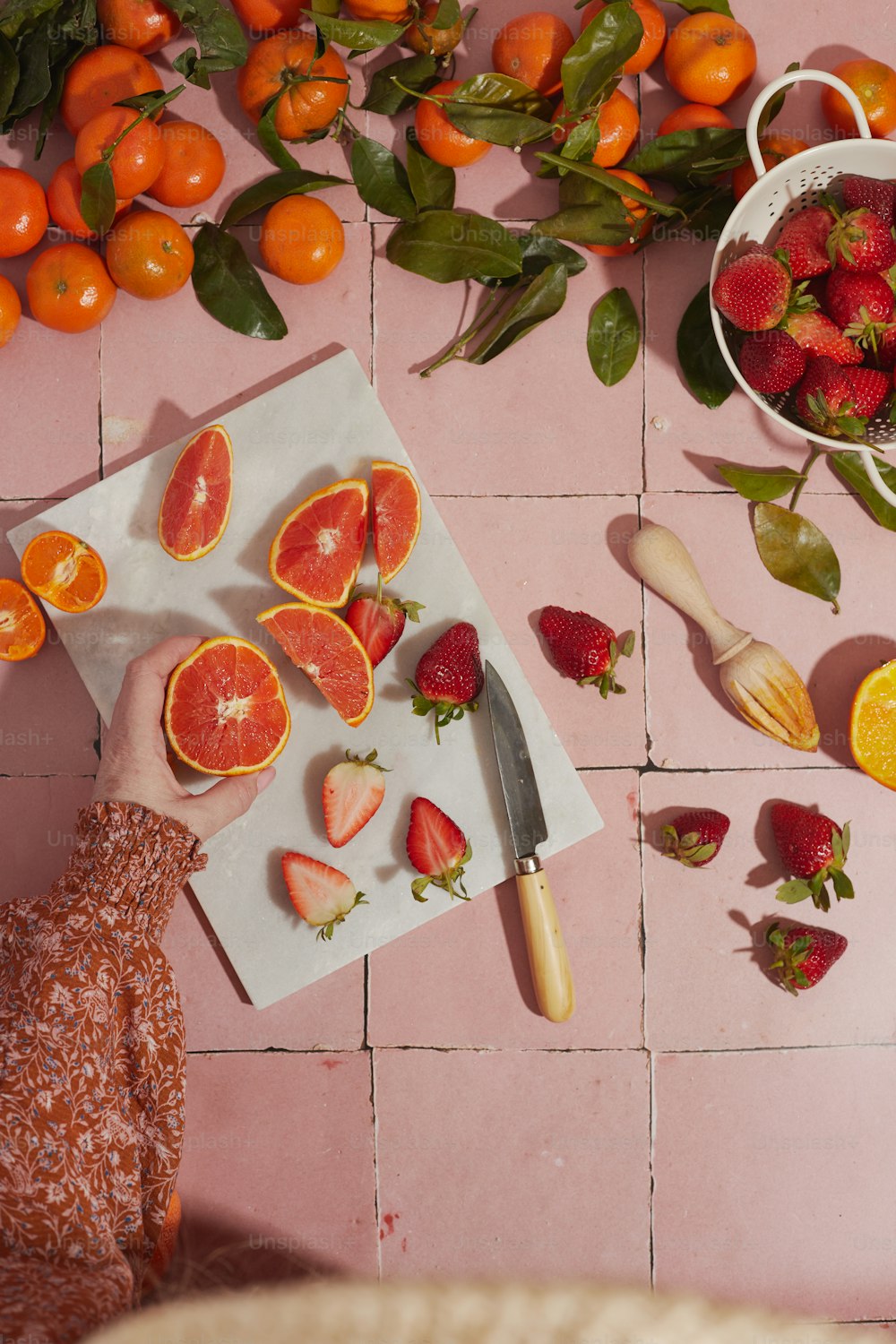 a person cutting up fruit on a cutting board