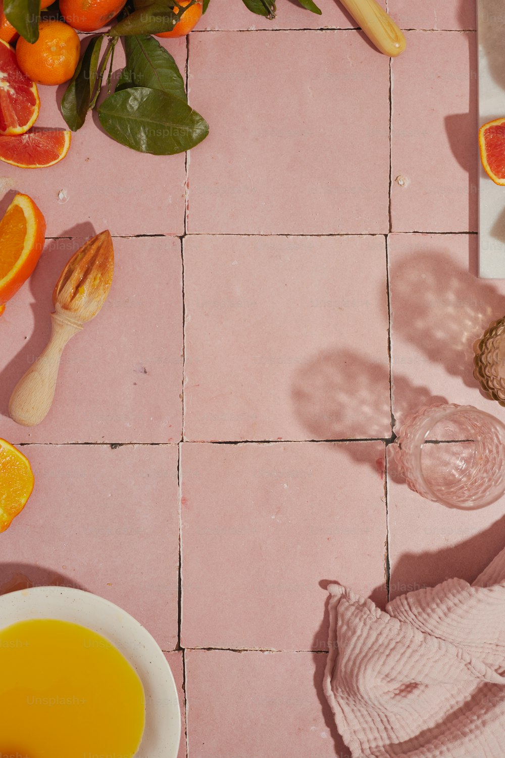 a pink tiled floor with oranges and other fruits