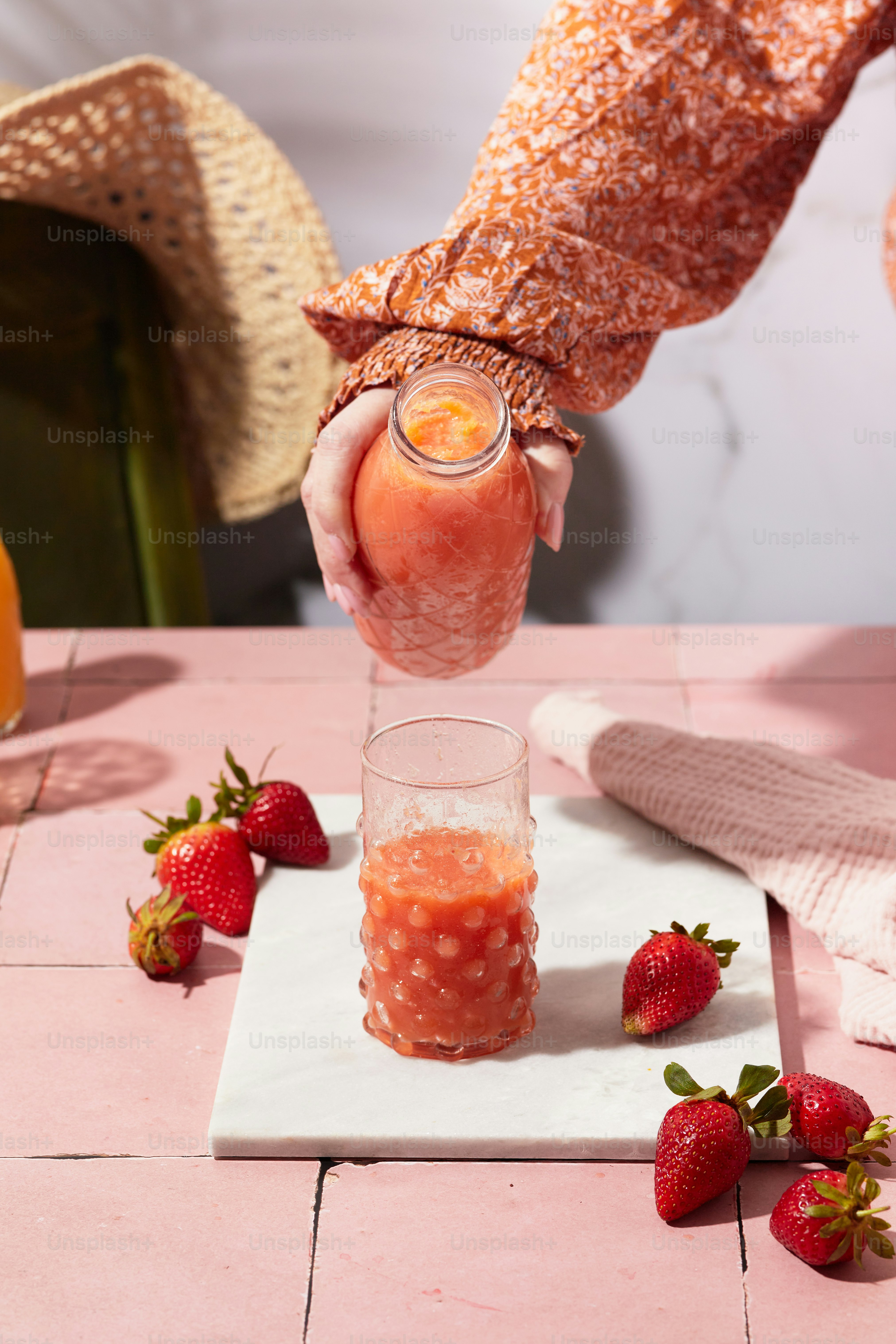 a person holding a glass with a drink in it