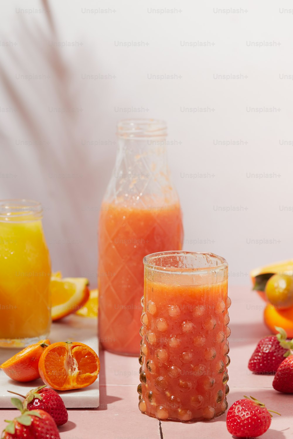 a table topped with glasses of juice and fruit