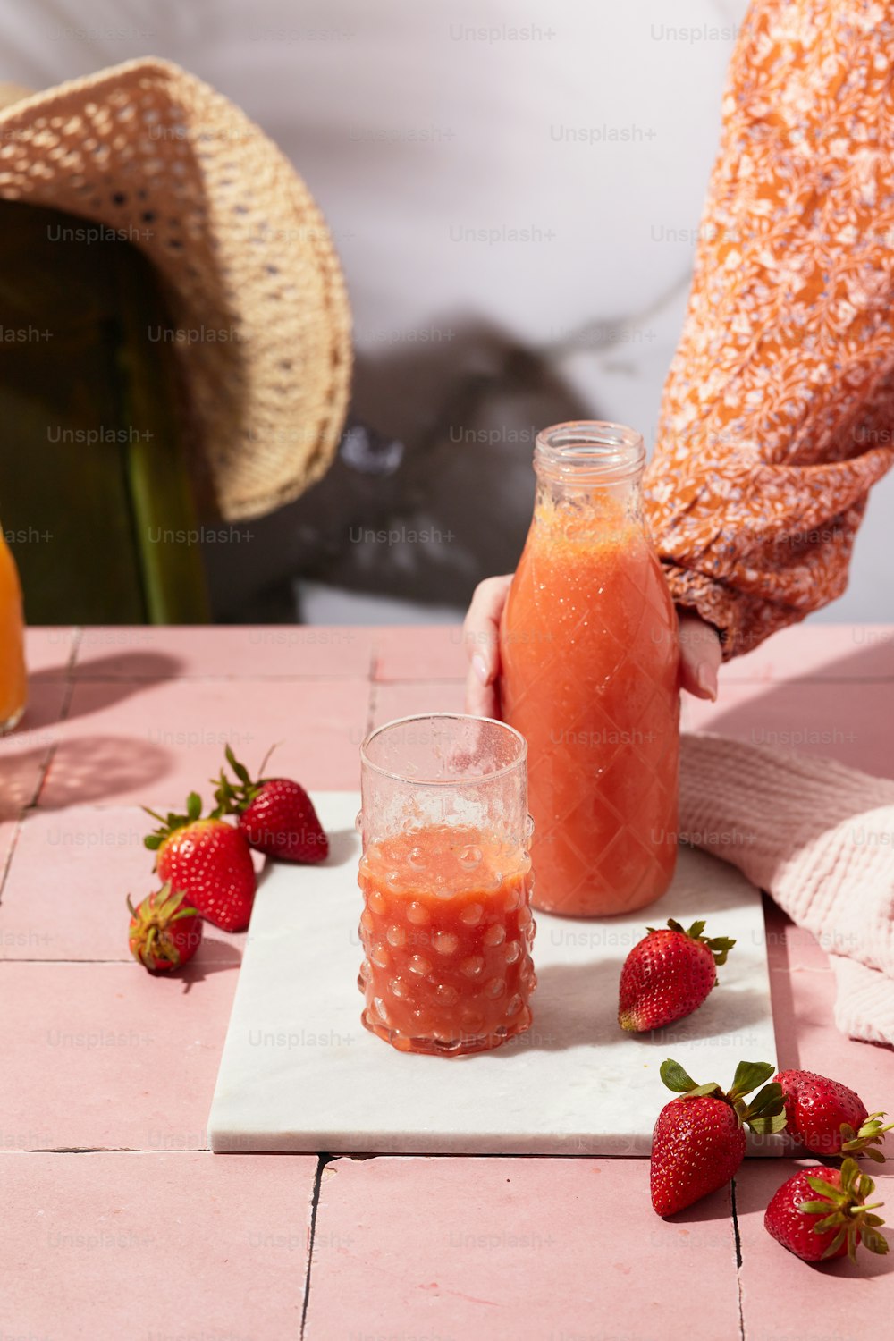 a person holding a glass of orange juice