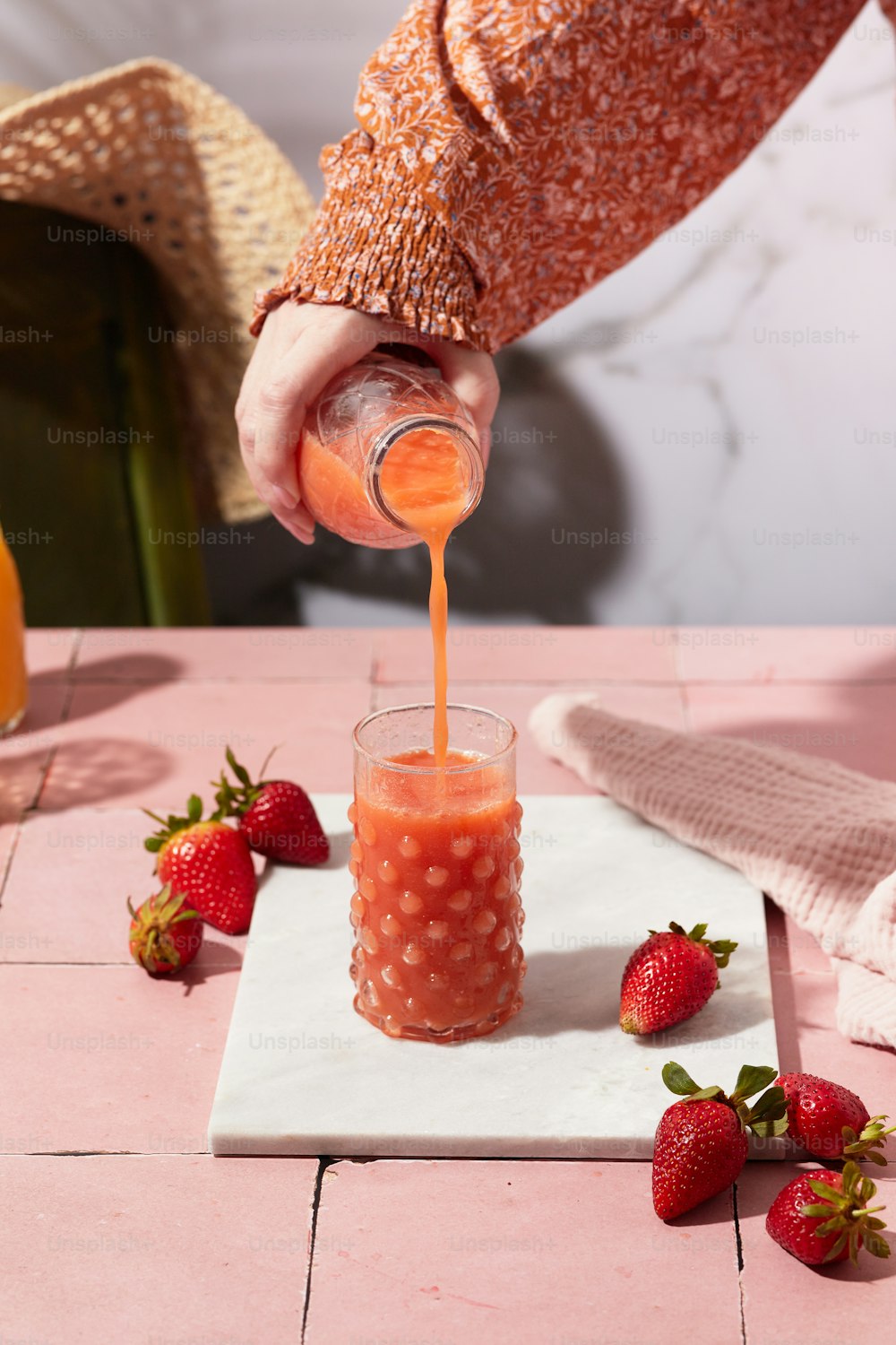 a person pouring a drink into a glass