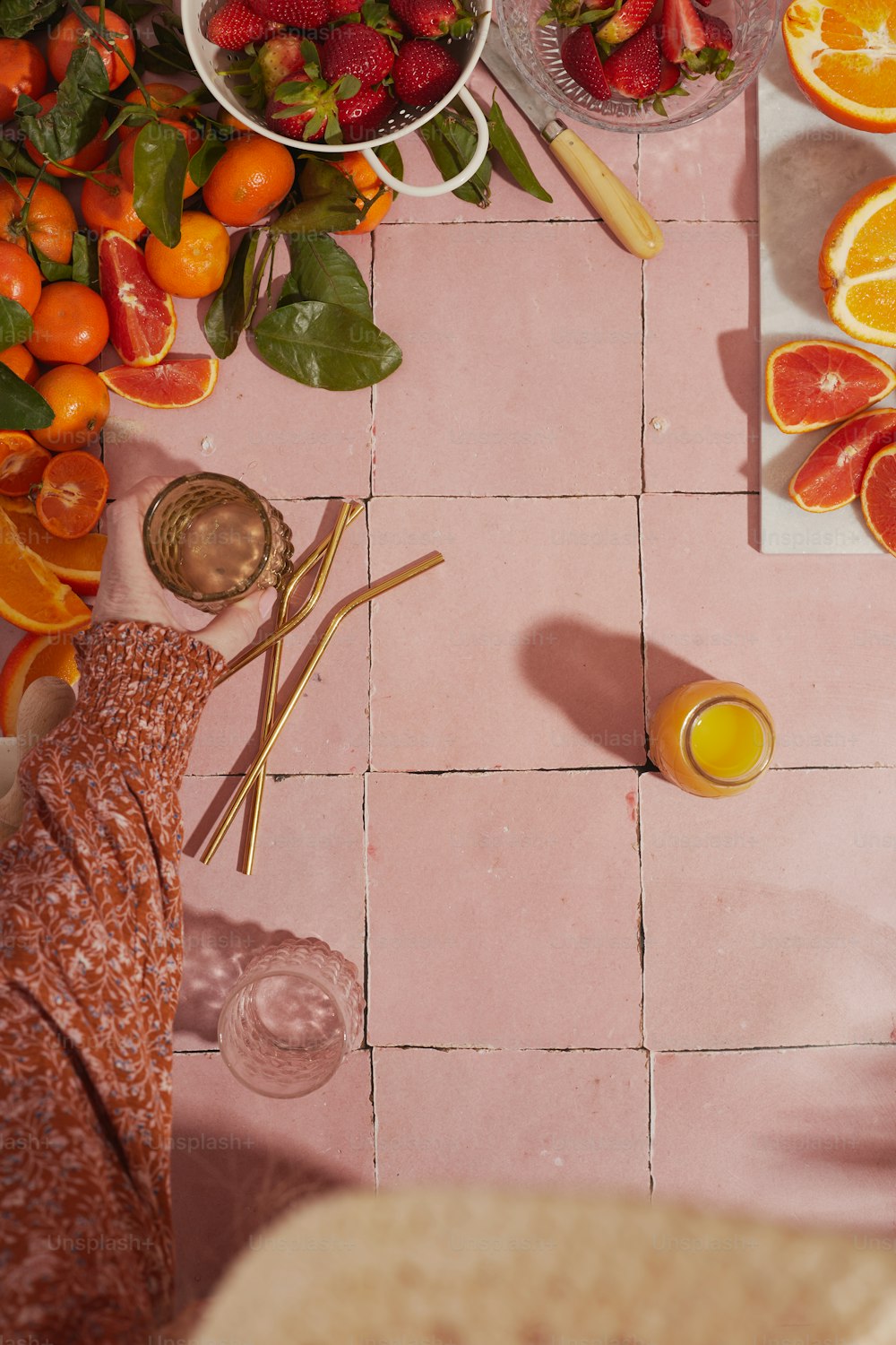 una mesa con naranjas, fresas y otras frutas