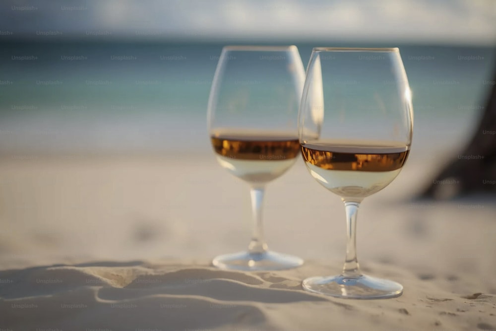 모래 사장 위에 앉아있는 두 잔의 와인