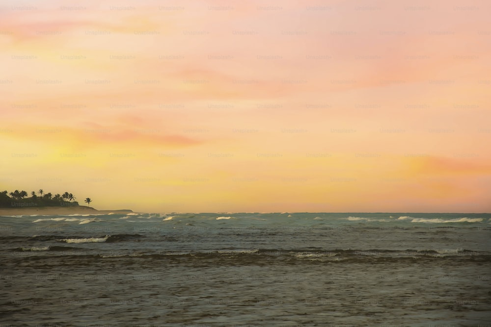une personne sur une planche de surf dans l’océan au coucher du soleil