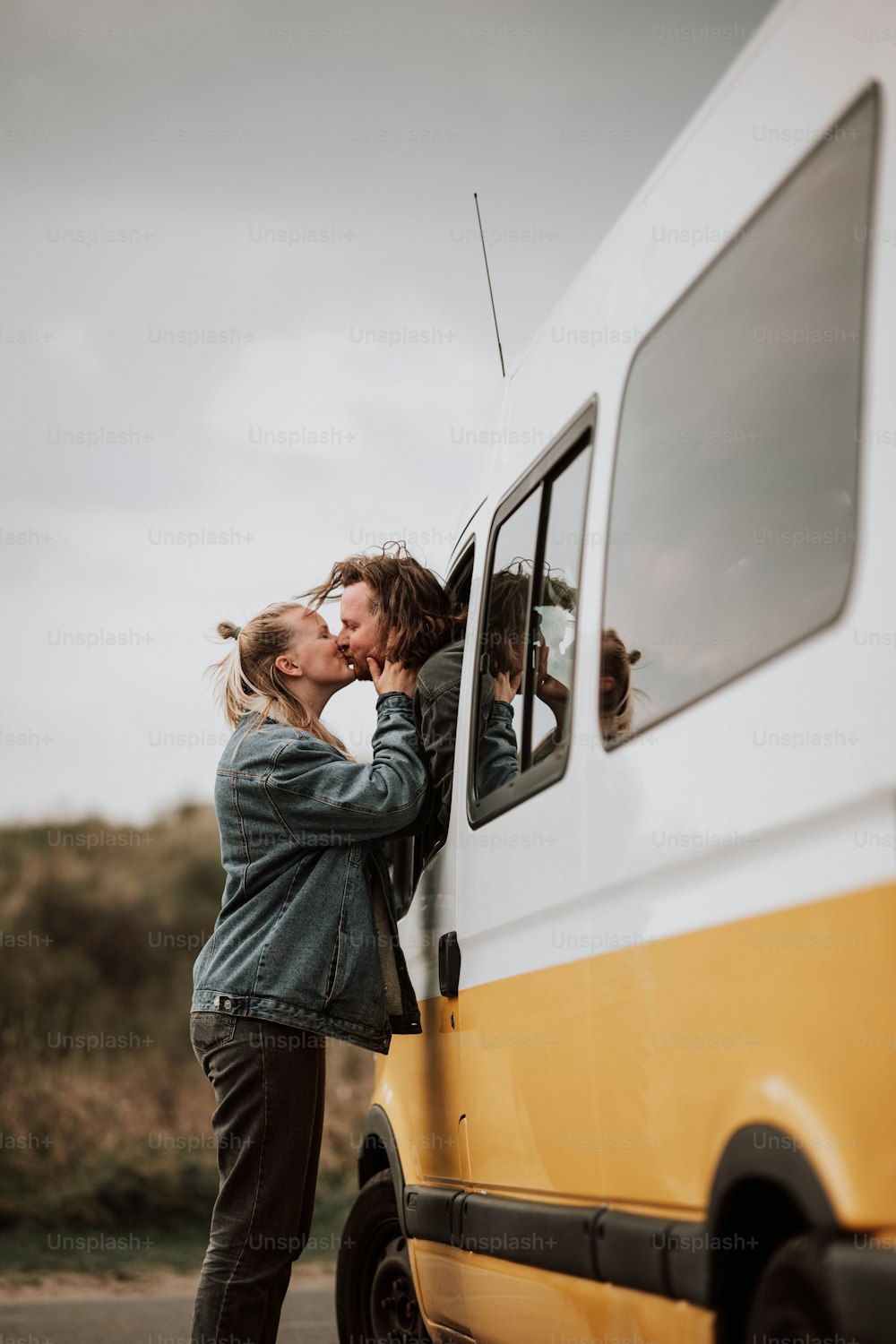 um par de pessoas que estão se beijando na parte de trás de uma van