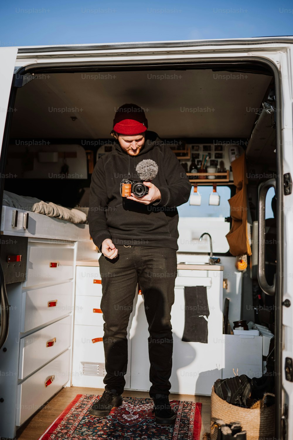 Un uomo in piedi nel retro di un furgone con in mano una macchina fotografica