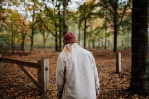 Un uomo con lunghi capelli bianchi cammina nel bosco