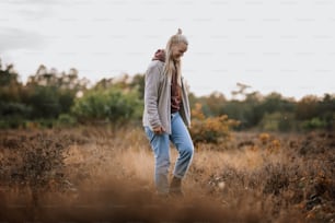 a woman standing in a field of tall grass