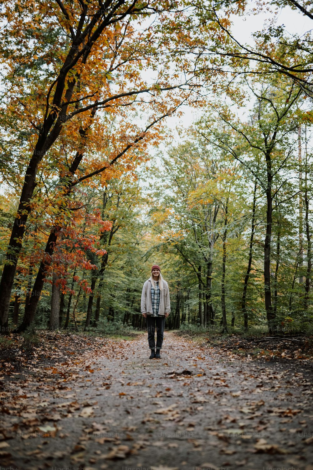 a man is walking down a path in the woods