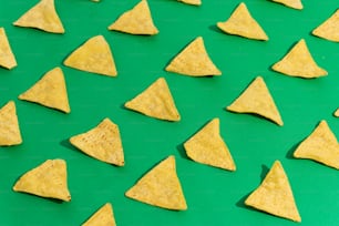 un groupe de croustilles de tortilla assis sur une surface verte