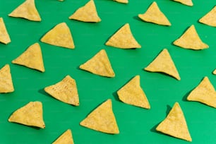 um grupo de chips de tortilha sentados em cima de uma superfície verde