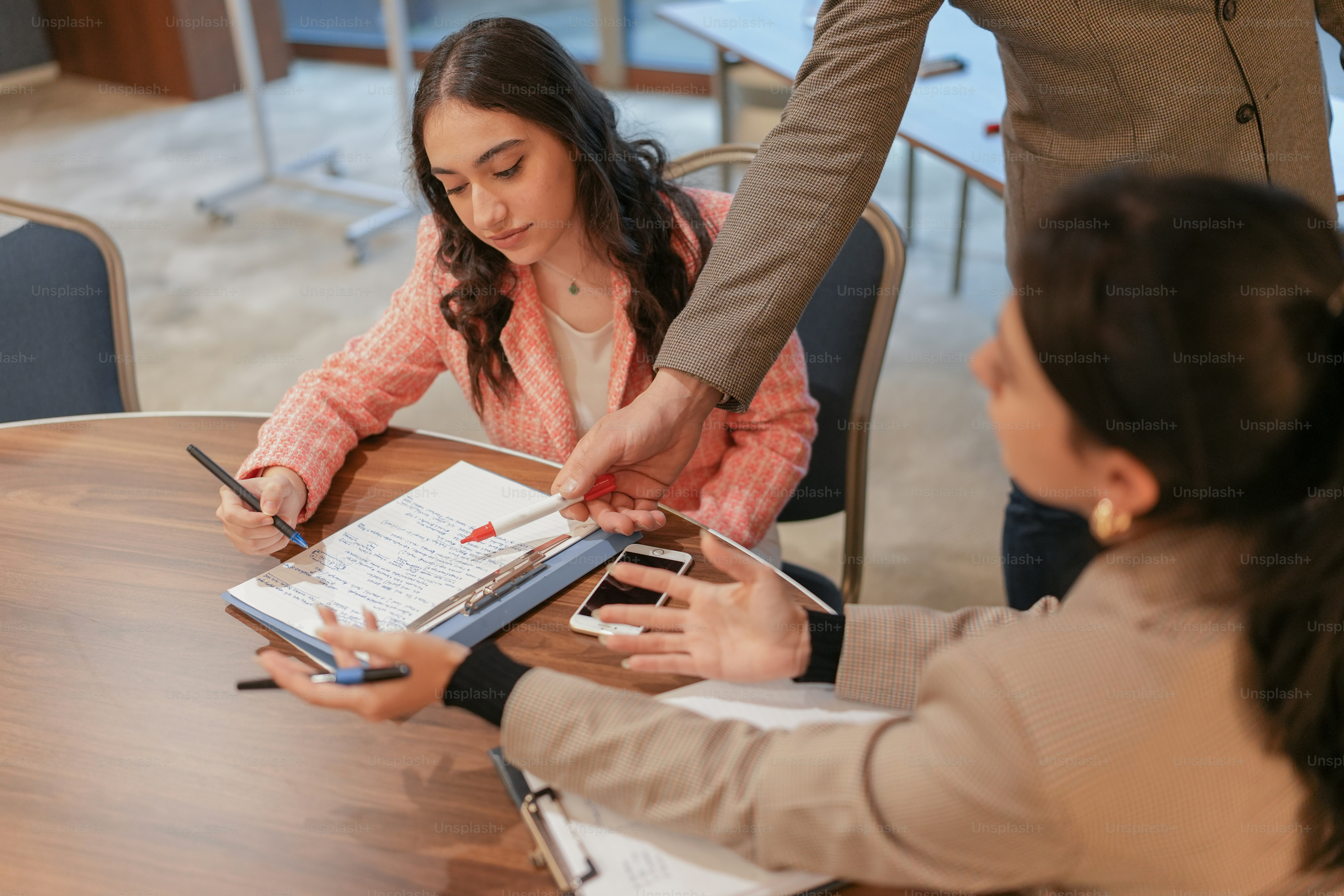 a group of people sitting around a wooden table