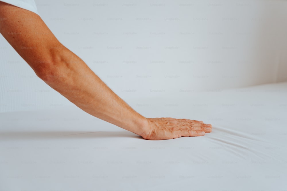 a person's hand reaching for something on a bed