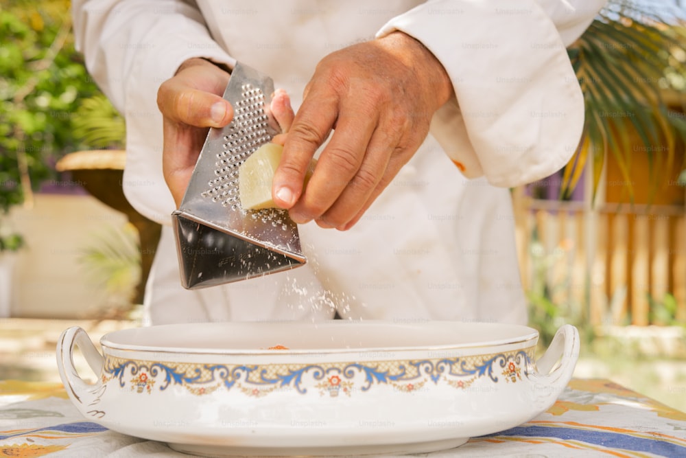 a chef grating something on a plate with a grater