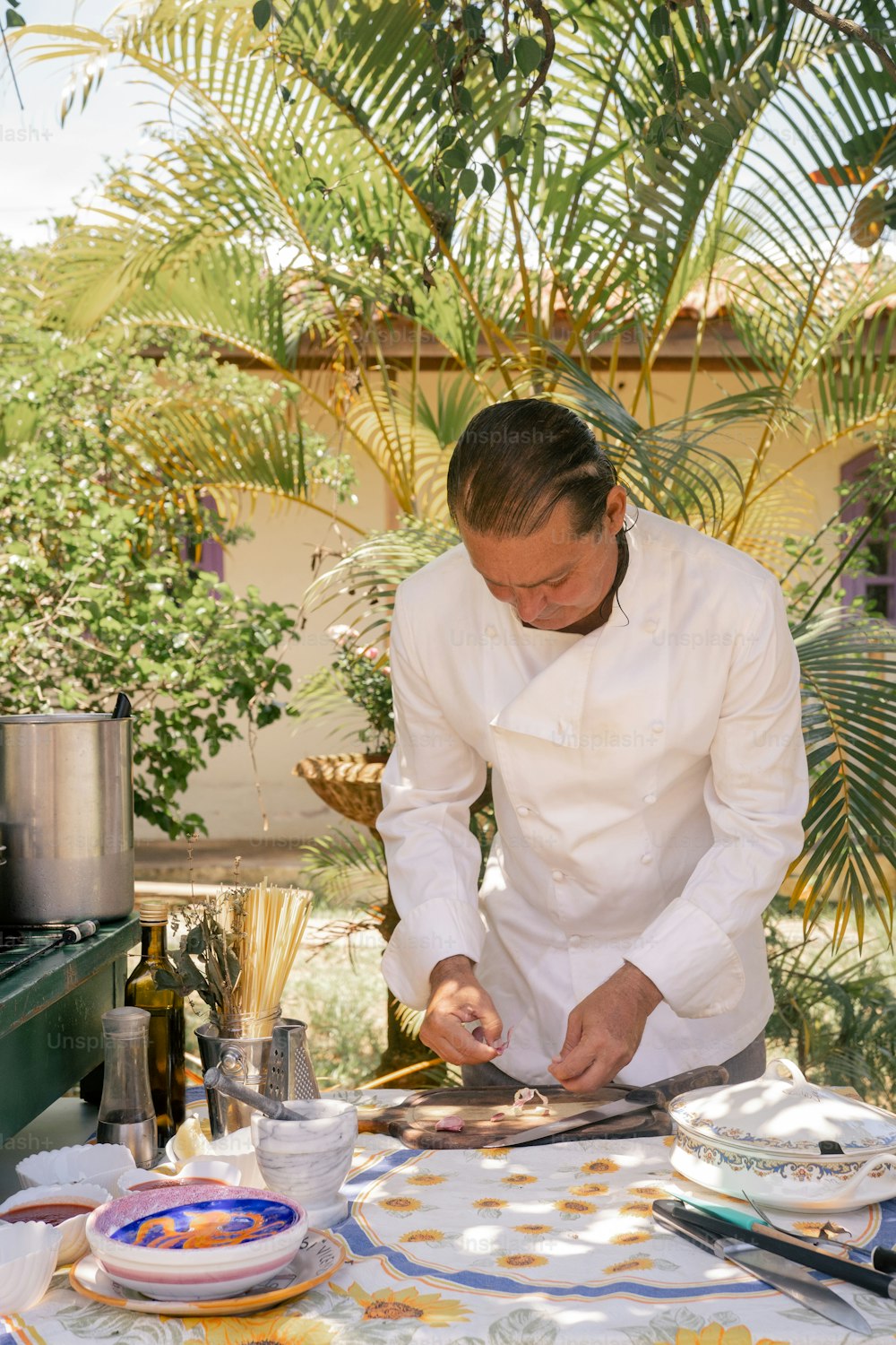 a man in a chef's uniform preparing food on a table