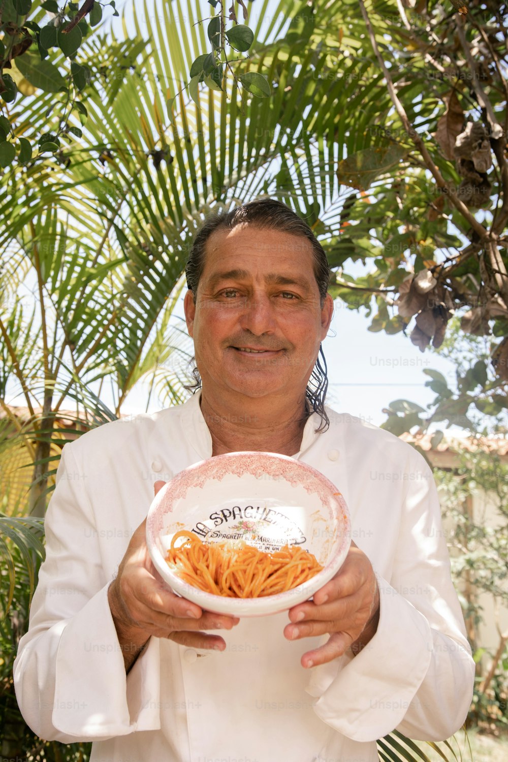 Un hombre sosteniendo un tazón de comida en sus manos