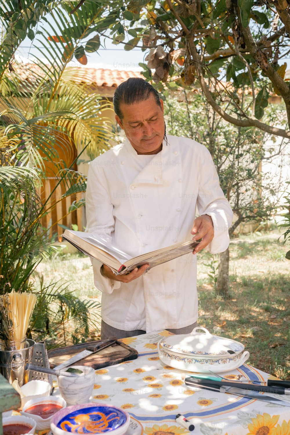 a man in a chef's coat reading a book
