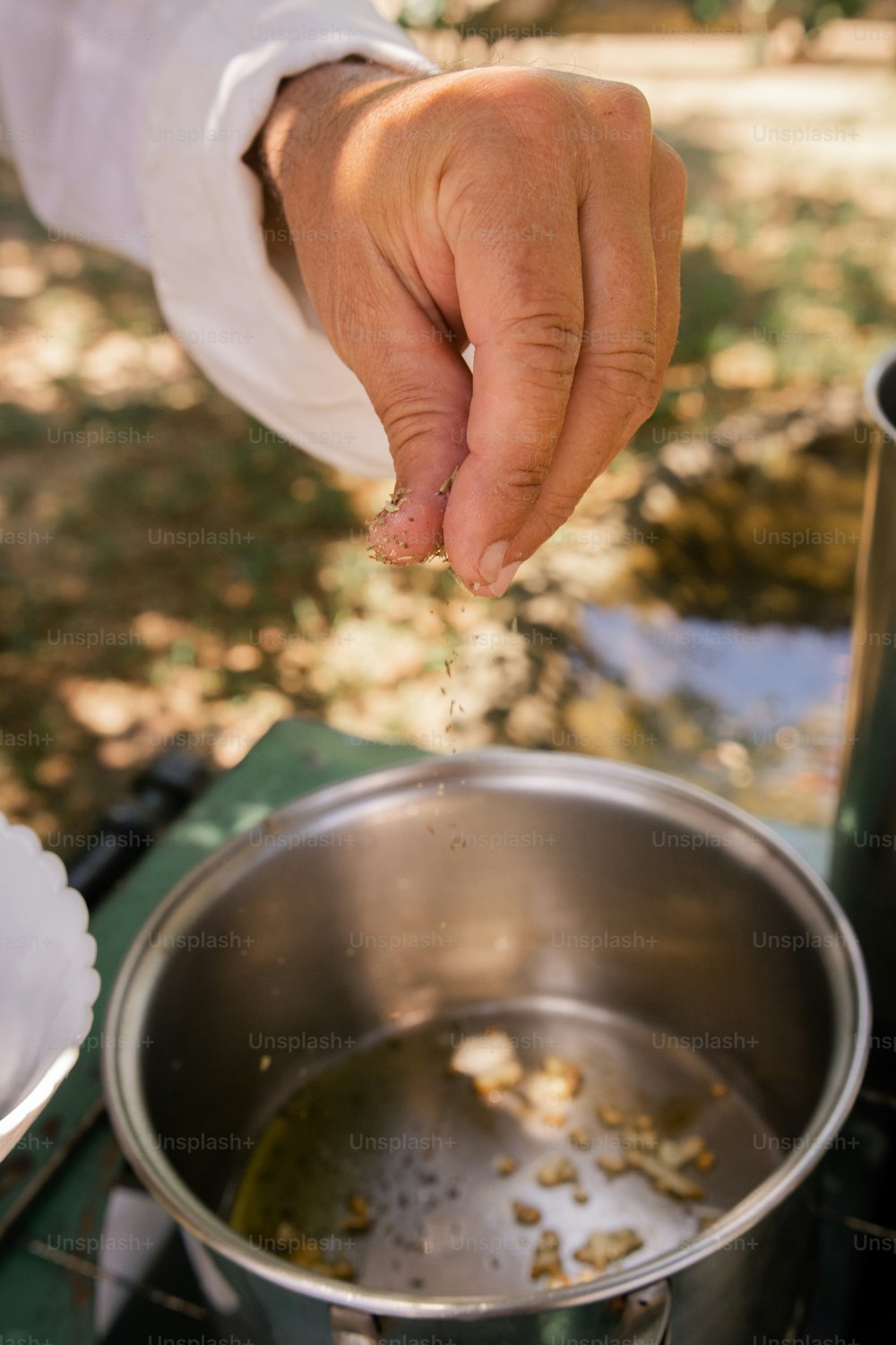 a person is sprinkling some food into a pot