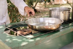 Una persona cocinando en una estufa con una sartén encima.