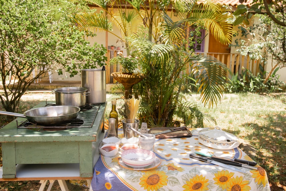 una mesa afuera con una olla y una sartén