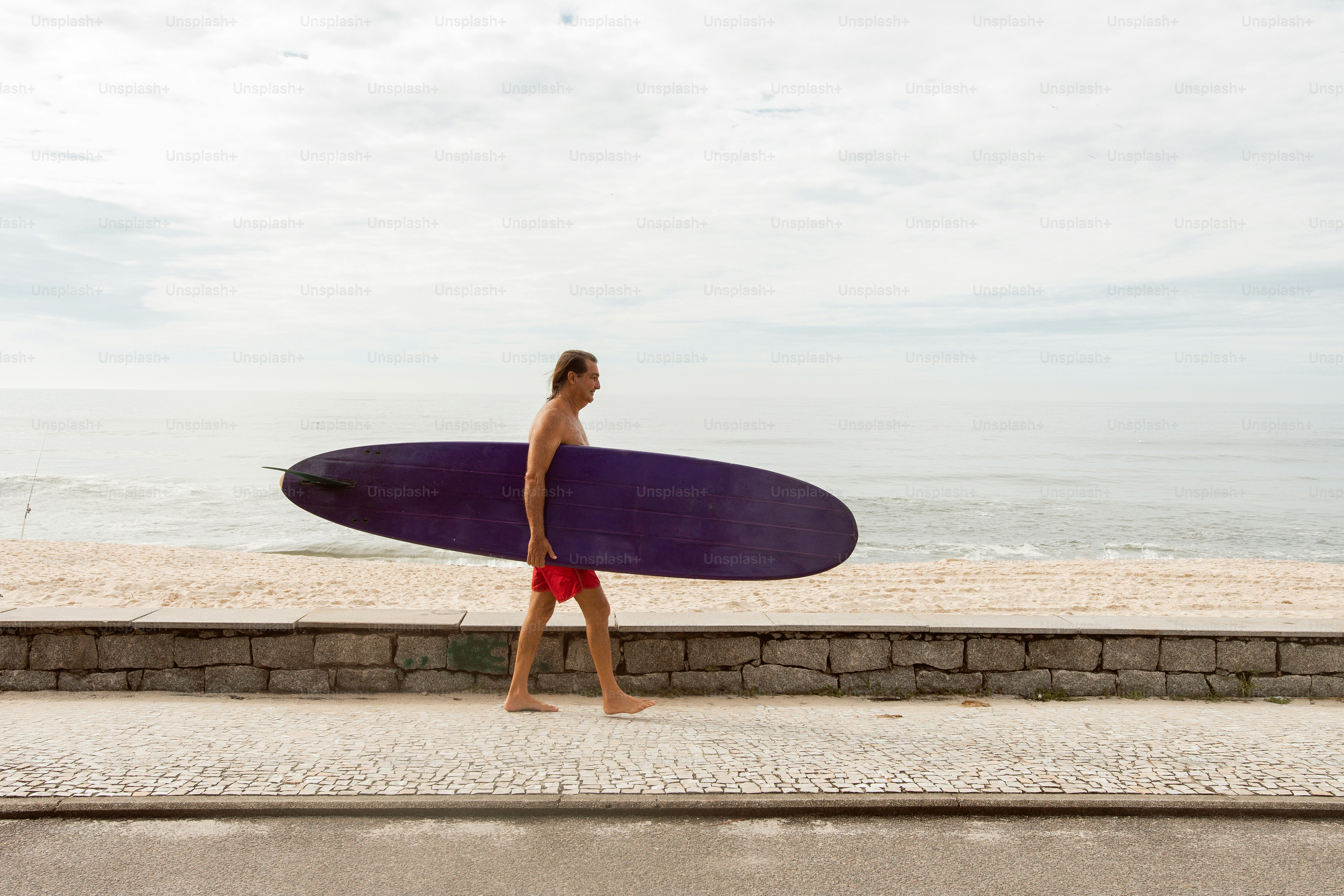 a man walking down the street with a surfboard