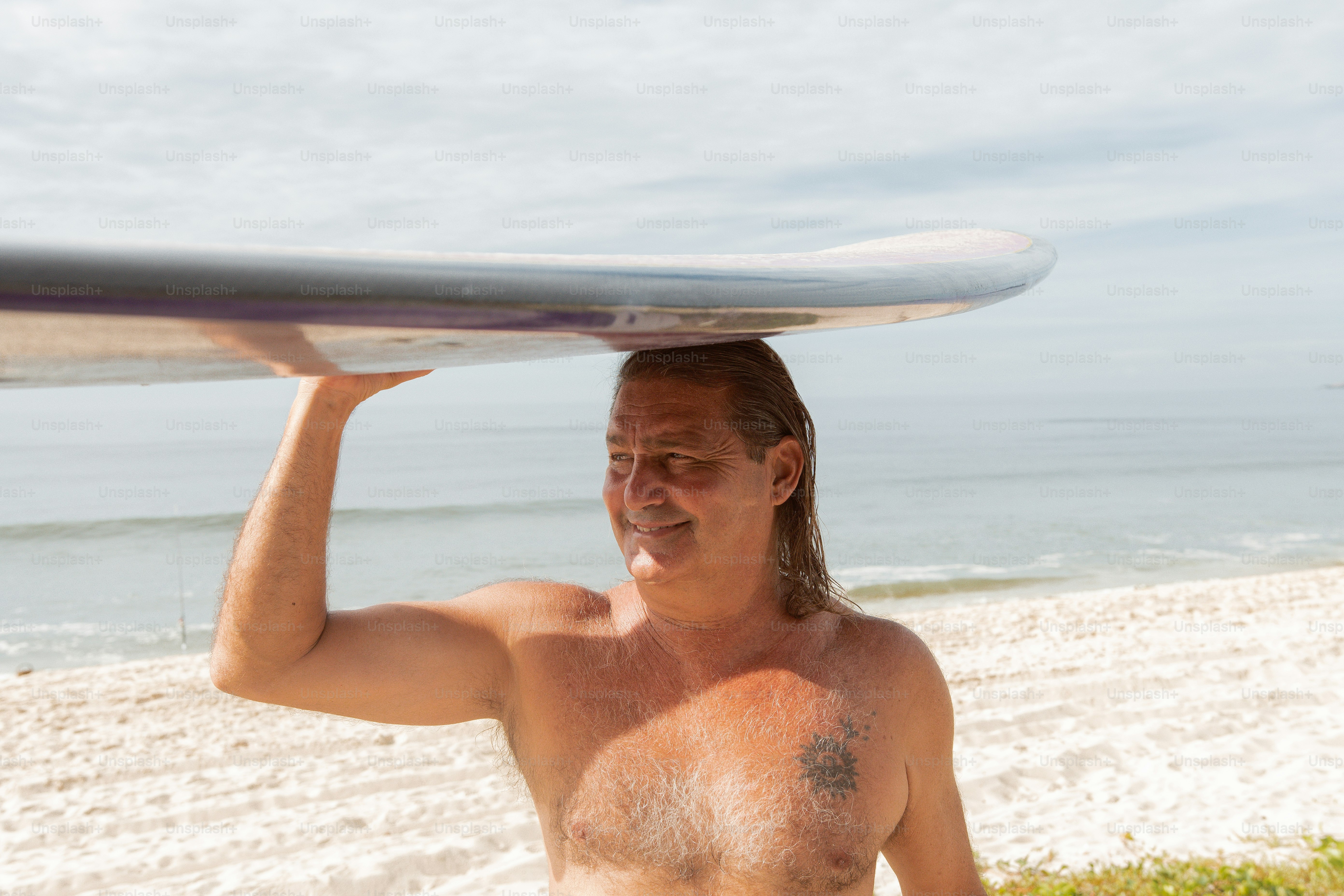 a man holding a surfboard over his head on the beach