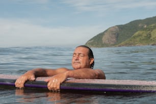 a man laying on a surfboard in the water