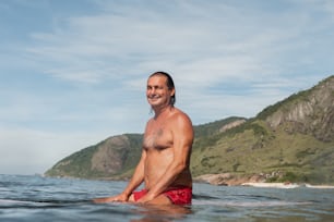 Ein Mann sitzt auf einem Surfbrett im Meer