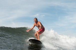 Un homme chevauchant une vague sur une planche de surf