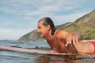 a man laying on a surfboard in the water