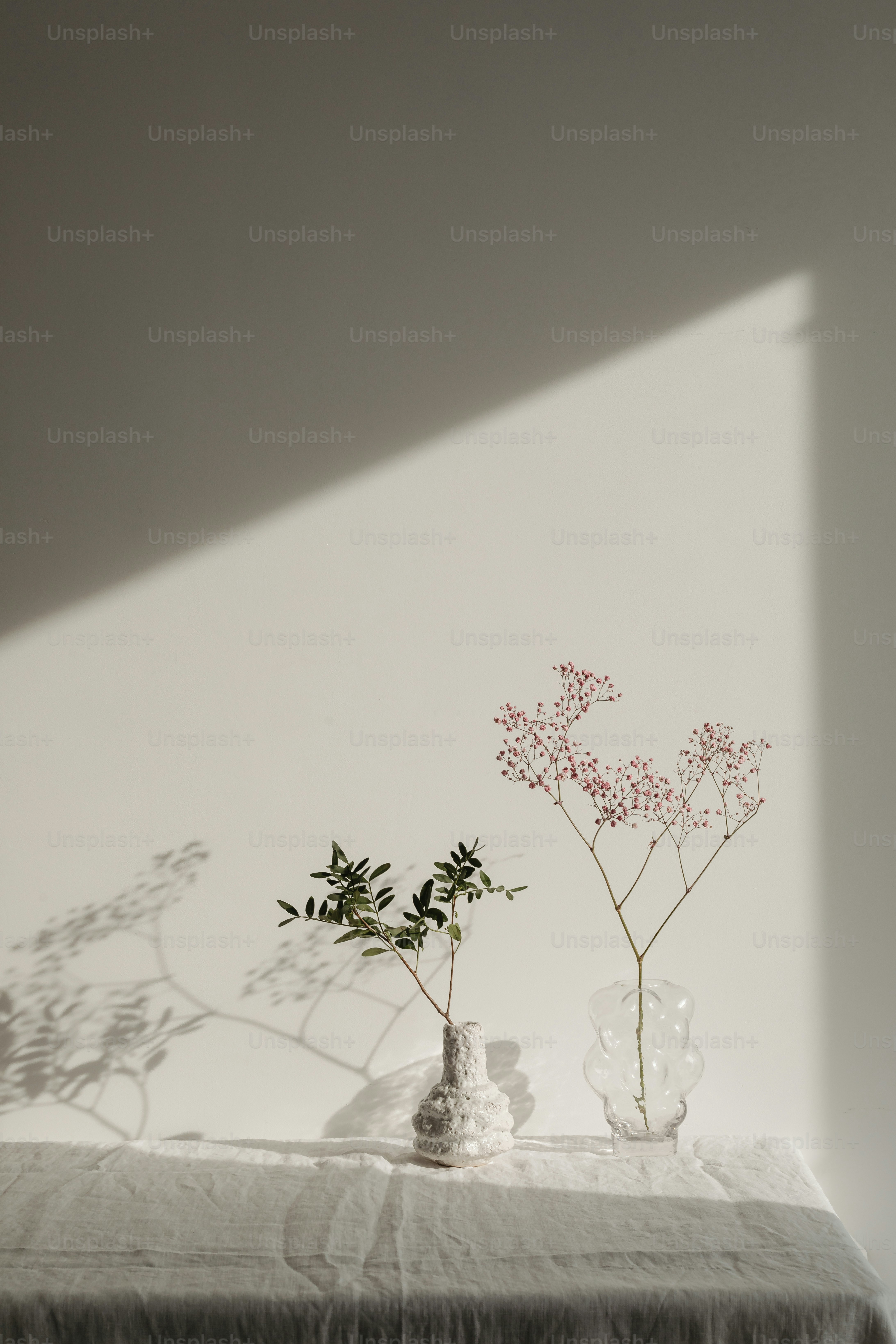 two vases with flowers are sitting on a table