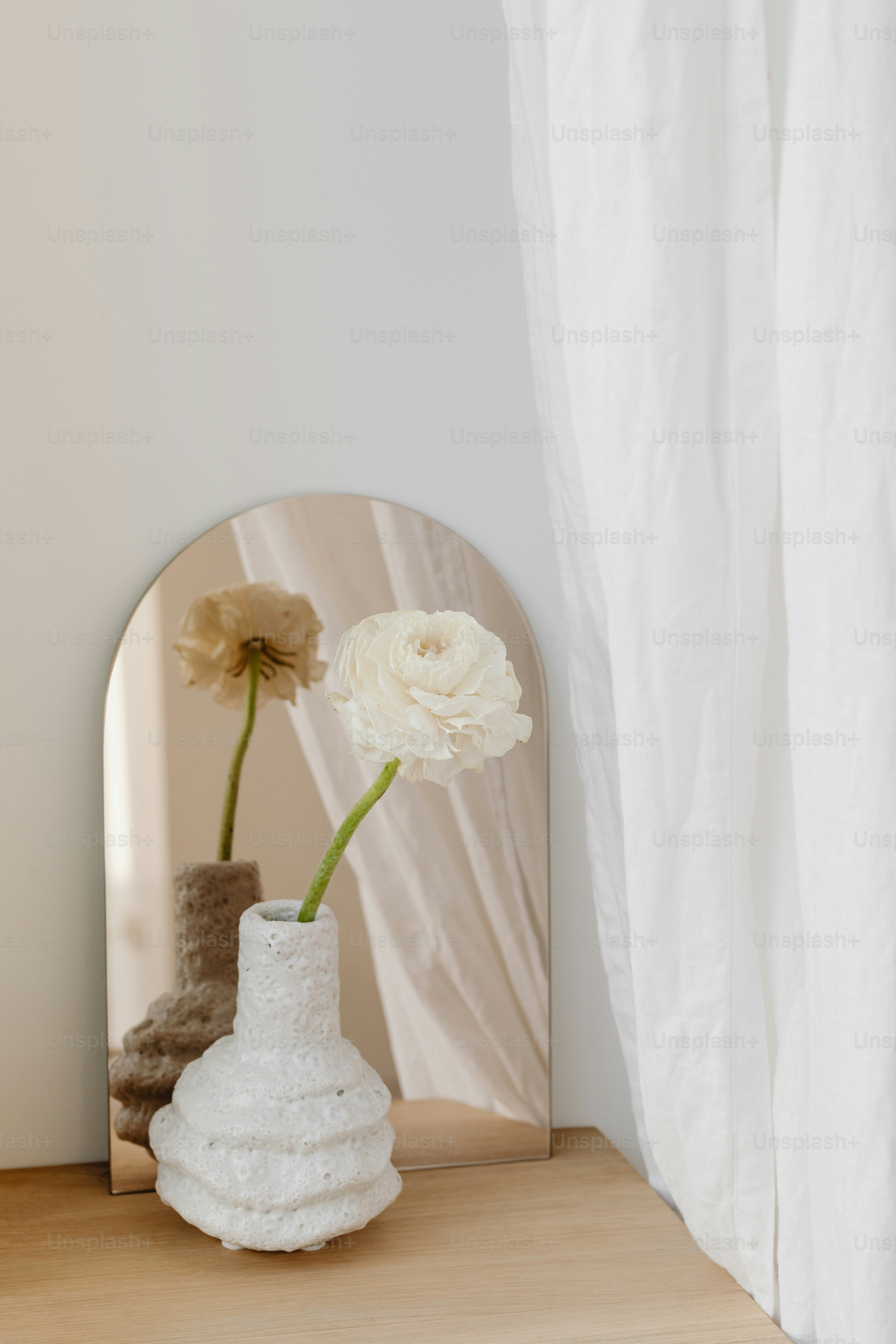 a white flower in a vase sitting on a table