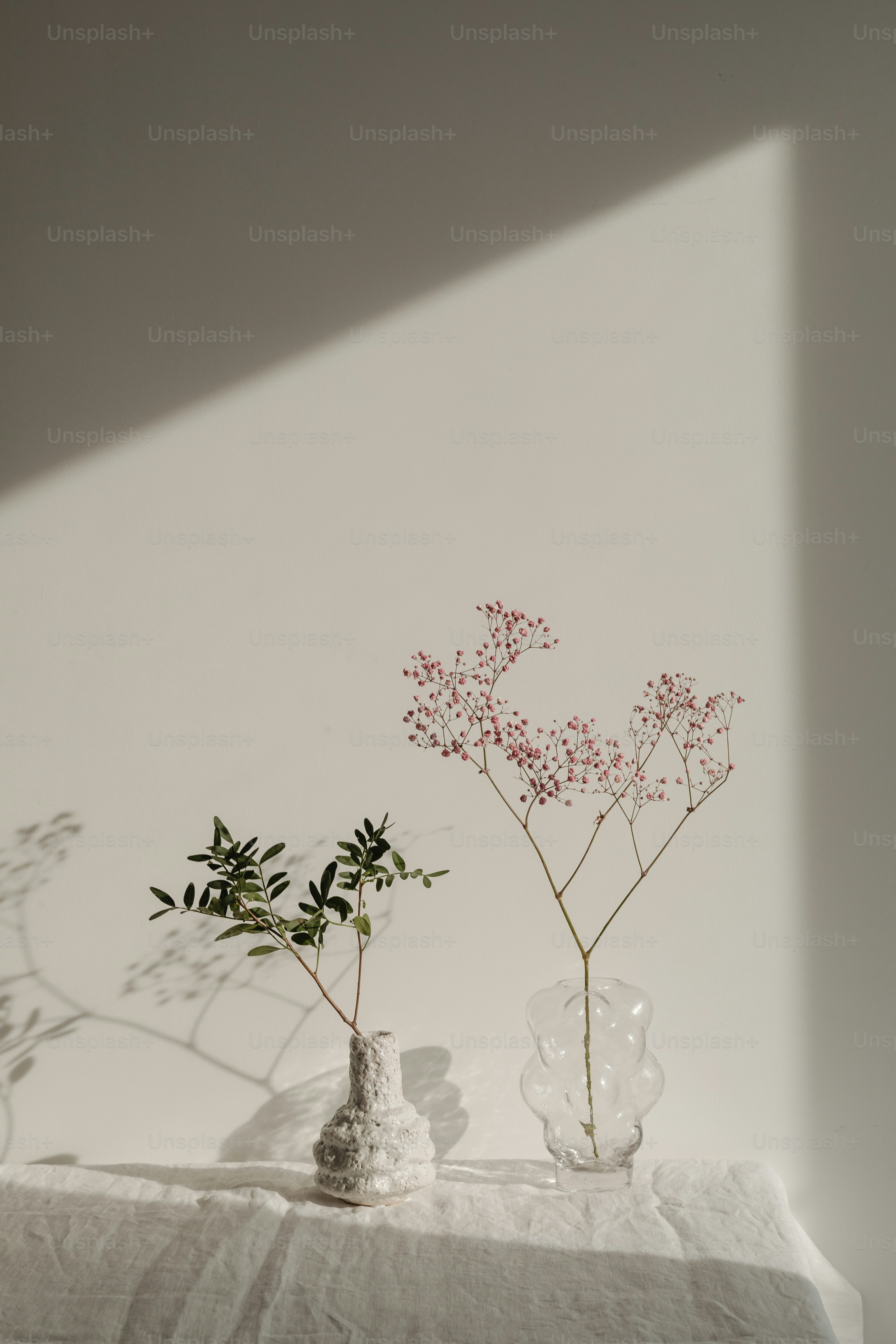 two vases with flowers are sitting on a table